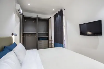 a bedroom with a white bed and a tv at Dimoro Suite in Rome