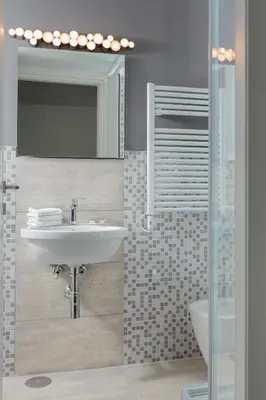 a bathroom with a sink and a mirror and a toilet at Margana Tower in Rome