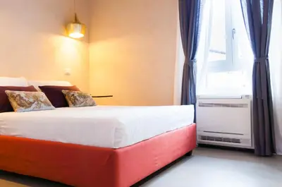 a bedroom with a red and white bed with a window at Margana Tower in Rome