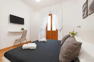 a bedroom with a bed and a couch and a television at White Flat Labicana in Rome