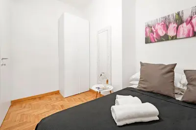 a bedroom with a black bed with pink flowers on the wall at White Flat Labicana in Rome
