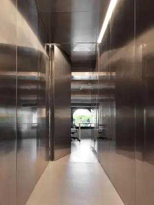 a hallway with stainless steel walls and a hallway with a table at Rhinoceros in Rome