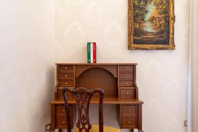 a wooden desk with a chair next to a dresser at Pantheon Escape in Rome