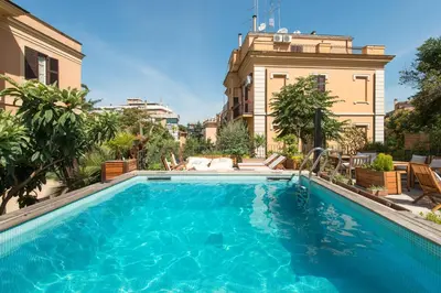 a large blue swimming pool in front of a building at Palm Gallery Hotel in Rome