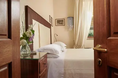 a bedroom with a bed with a mirror and a vase of flowers at Palm Gallery Hotel in Rome