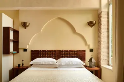 a bedroom with a bed with two white pillows at Palm Gallery Hotel in Rome