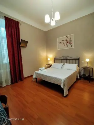 a bedroom with a bed and a red curtain at Rossi Hotel in Rome