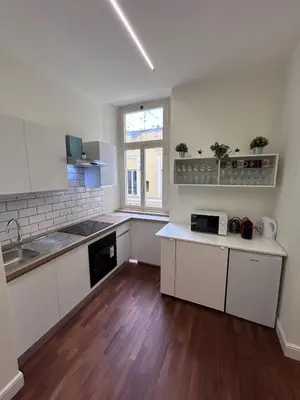 an empty kitchen with white cabinets and a window at San Peter Lory's Aparts in Rome