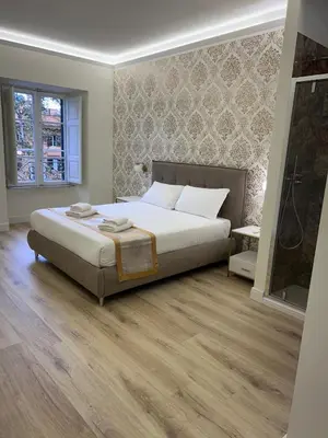 a bedroom with a large white bed and wooden floors at San Peter Lory's Aparts in Rome