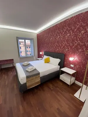 a bedroom with a bed and a red wall at San Peter Lory's Aparts in Rome