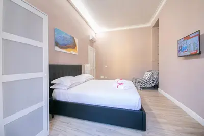 a bedroom with a white bed with towels on it at San Peter Lory's Aparts in Rome