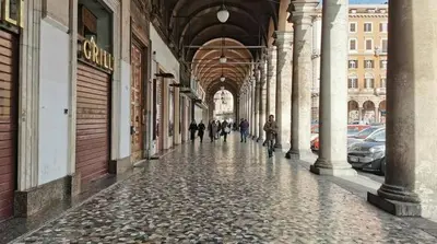 people walking down a cobblestone street in a building at Ugo Foscolo in Rome