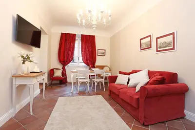 a living room with a red couch and a table at Daplace - Gaia Apartment in Rome