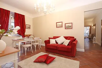 a living room with a red couch and a table at Daplace - Gaia Apartment in Rome
