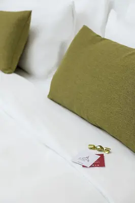 a pair of gold rings sitting on a bed with a envelope at St. Peter Fortytwo in Rome