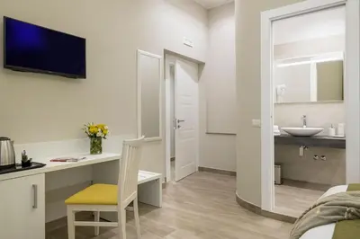 a bedroom with a desk and a sink and a bed at St. Peter Fortytwo in Rome