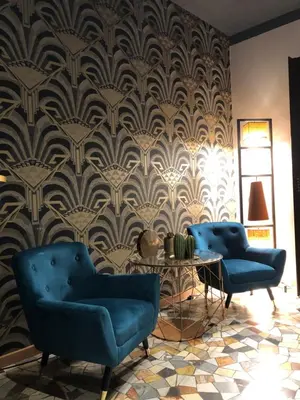 a living room with two blue chairs and a wallpaper at Mi Hotel Home in Rome