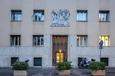 a building with a statue on the side of it at Mi Hotel Home in Rome