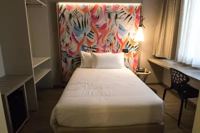 a hotel room with a bed and a colorful wall at Hotel San Giovanni Roma in Rome