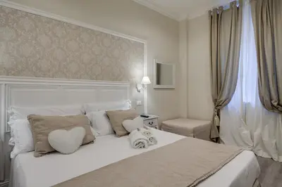 a bedroom with a white bed with a heart pillow at Charme & Chic Luxury in Rome