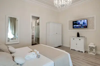 a white bedroom with a bed and a sink at Charme & Chic Luxury in Rome