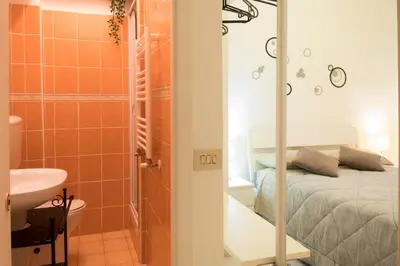 a bathroom with a bed and a shower and a sink at Casa Gaby in Rome