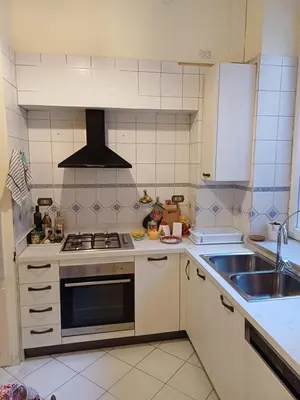 a kitchen with a stove and a sink at The Queen's Coffer Rome in Rome