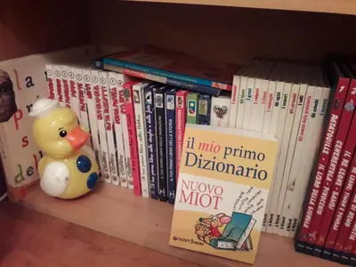 a shelf with books and a rubber duck and books at The Queen's Coffer Rome in Rome