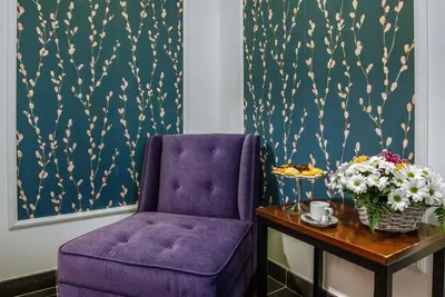 a purple chair sitting next to a table with flowers at Navona Colors Hotel in Rome