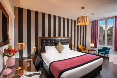 a hotel room with a bed and a desk and chairs at Navona Colors Hotel in Rome