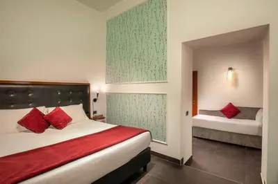 a hotel room with a bed with red pillows at Navona Colors Hotel in Rome