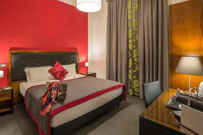 a bedroom with a bed with a red wall at Navona Colors Hotel in Rome