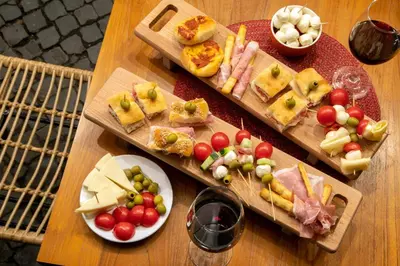 a wooden table topped with plates of food and glasses of wine at Navona Colors Hotel in Rome
