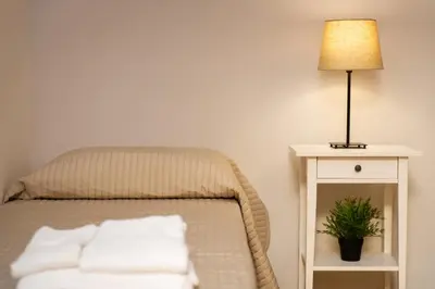 a bed with white pillows and a lamp on a table at Domus Candia in Rome