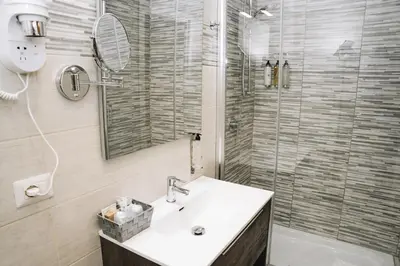 a bathroom with a sink and a glass shower at 47 Steps in Rome