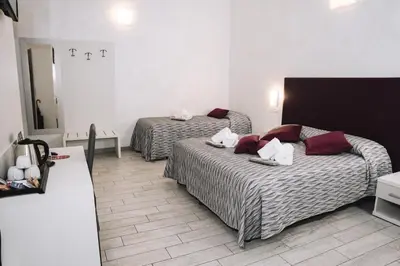 a hotel room with two beds and a mirror at 47 Steps in Rome