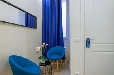 two blue chairs in a room with a window at Pantheon Unique Rooms in Rome