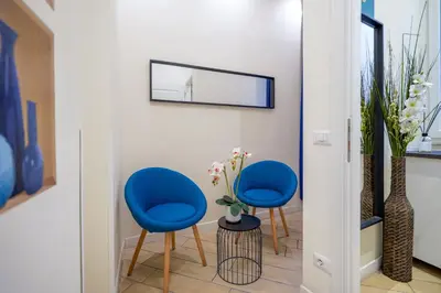 a hallway with two blue chairs and a mirror at Pantheon Unique Rooms in Rome