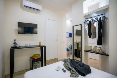 a room with a bed and a tv and a mirror at Pantheon Unique Rooms in Rome