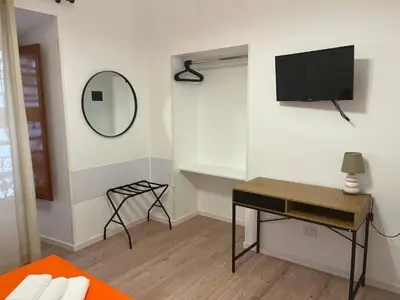 a living room with a desk and a tv on the wall at Ottaviano Lodge in Rome