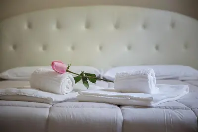 a couple of towels and a rose on a bed at Marbel - Casa vacanze in Rome