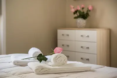 a bedroom with towels and flowers on a bed at Marbel - Casa vacanze in Rome
