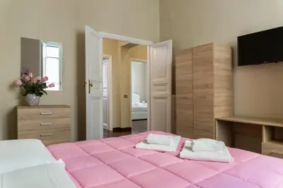 a bedroom with a pink bed with two towels at Marbel - Casa vacanze in Rome