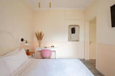 a bedroom with a white bed and a desk at Dante's in Vaticano 2 in Rome