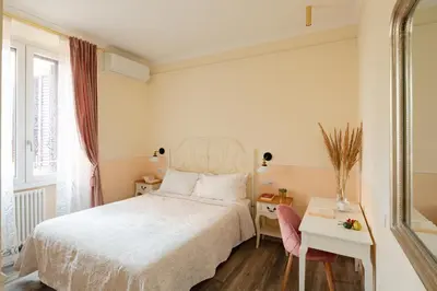 a bedroom with a bed and a table and a window at Dante's in Vaticano 2 in Rome