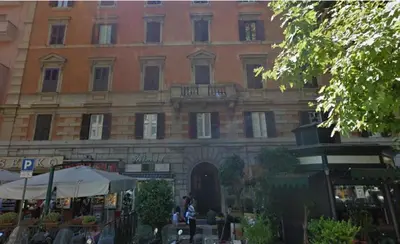 a large brick building with people sitting in front of it at Dante's in Vaticano 2 in Rome