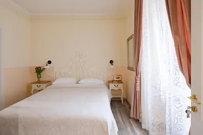 a bedroom with a white bed and a window at Dante's in Vaticano 2 in Rome