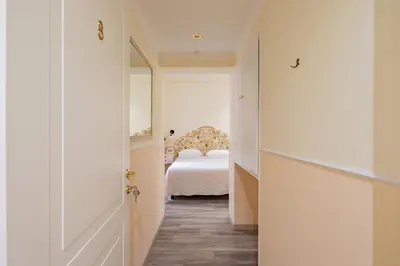 a small bedroom with a bed and a mirror at Dante's in Vaticano 2 in Rome