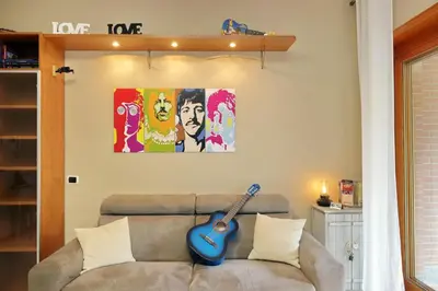 a living room with a couch with a guitar on the wall at Aurelia Relax Apartment in Rome