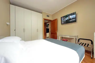 a bedroom with a white bed and a tv on the wall at Aurelia Relax Apartment in Rome